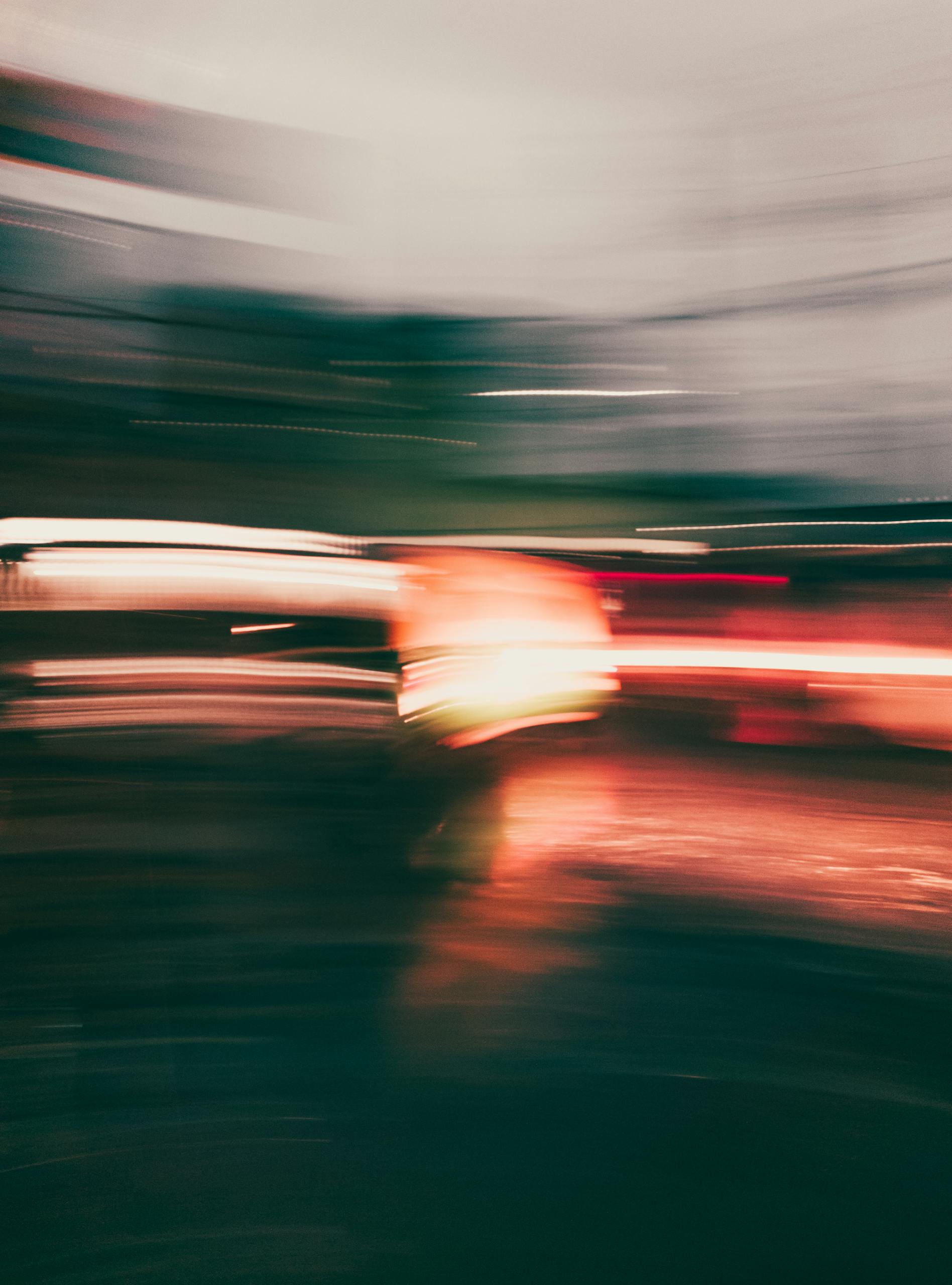 Abstract blurred motion of city lights captured in vibrant colors, creating a dynamic visual effect.